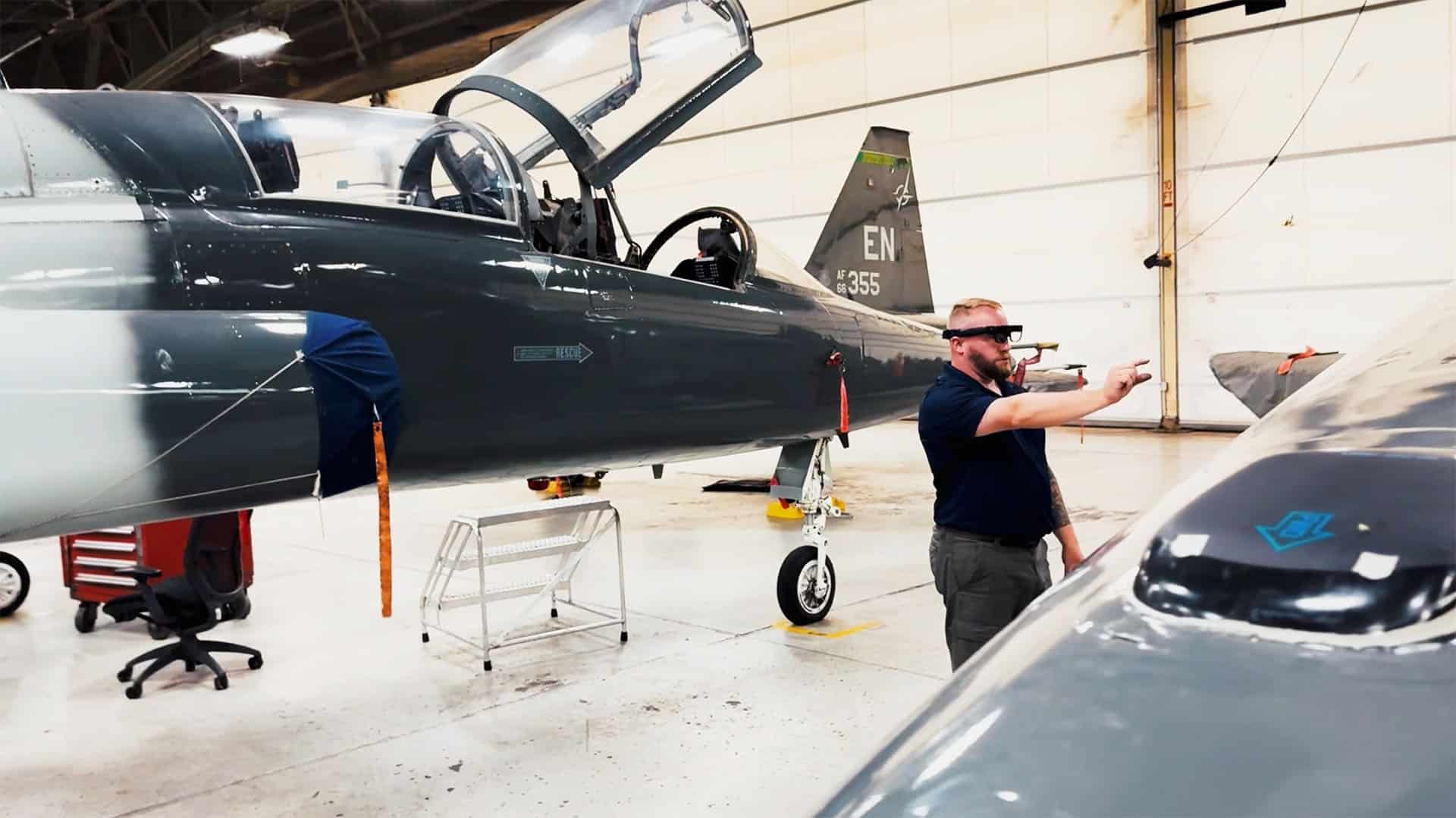 Technician wearing smartglasses reviewing aircraft in a maintenance hangar